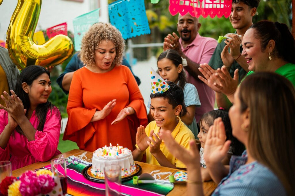 Child boy celebrating his birthday with family outdoors