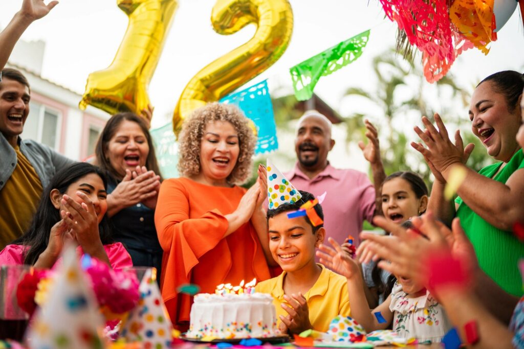 Child boy celebrating his birthday with family outdoors